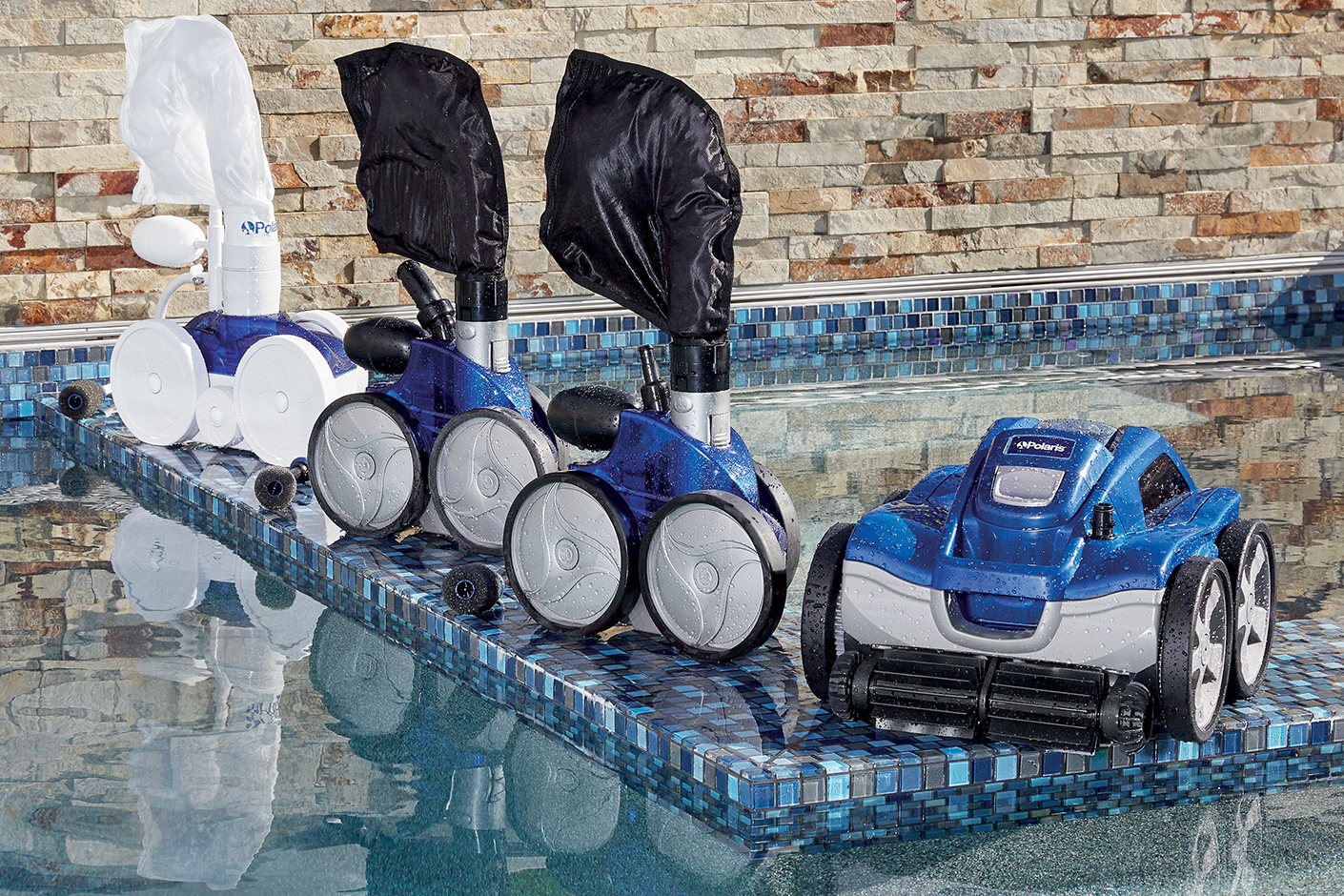 Polaris Pool Cleaner Lineup Next to Pool